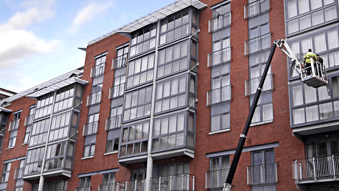 Commercial window cleaners using a hydraulic platform to clean windows.