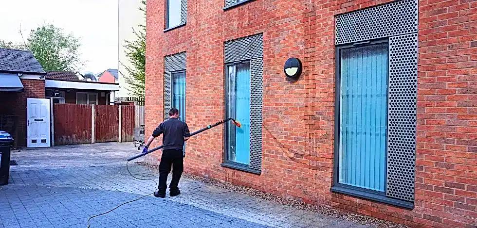 Commercialwindowcleanerpole Commercial window cleaner using water-fed pole.